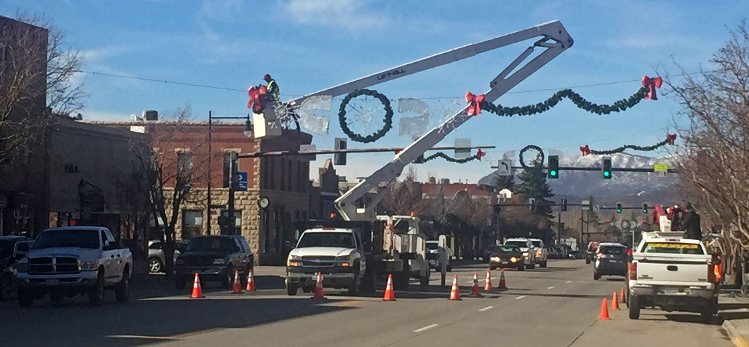 Street crews work to add holiday decorations and lights above Lincoln Avenue