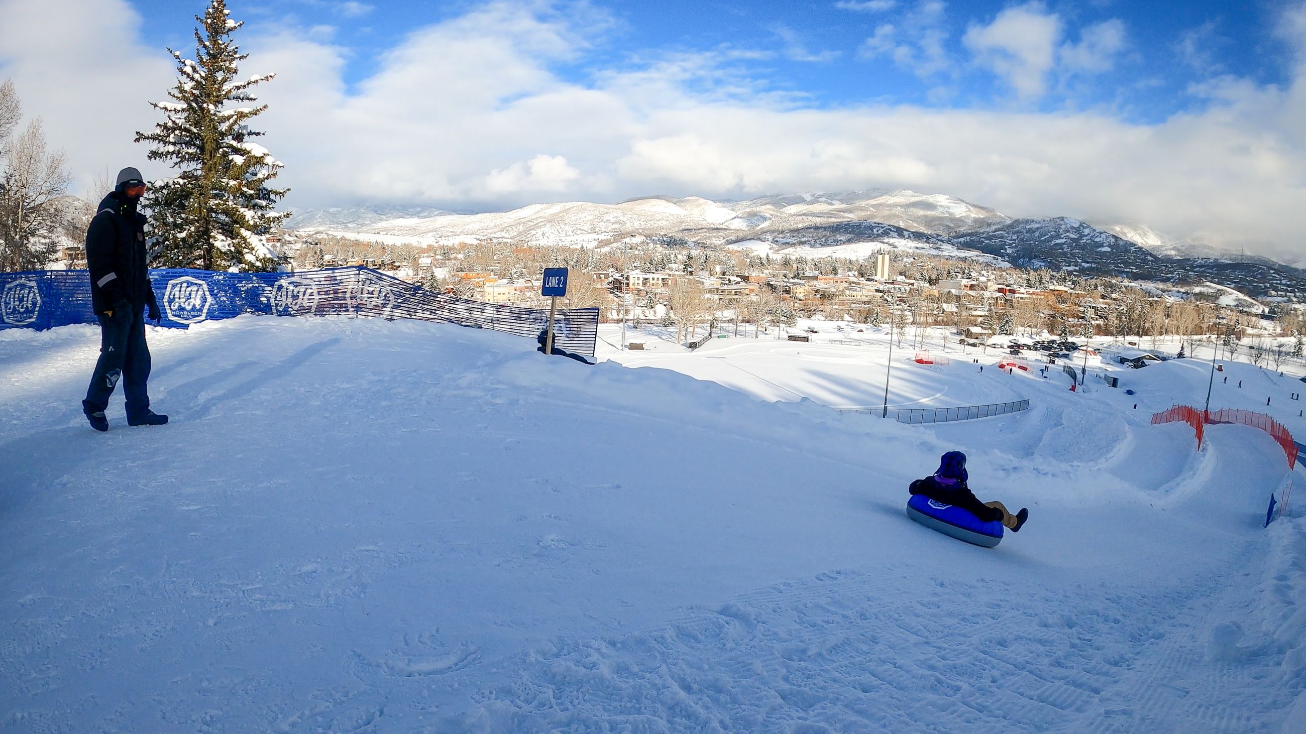 A child heads down the hill on a snow tube